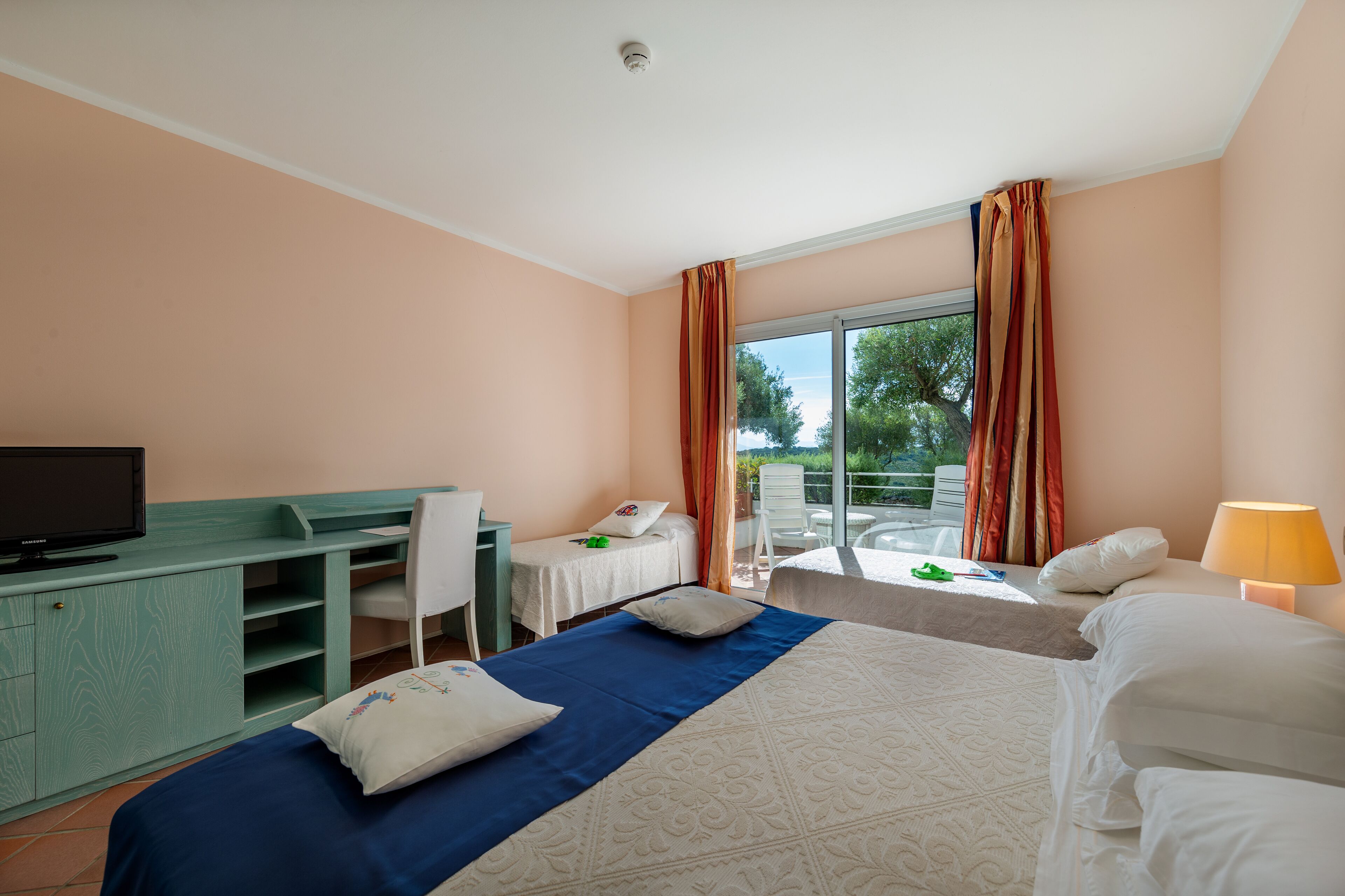 Une chambre d’hôtel équipée d’un lit, d’un bureau, d’une chaise et d’un téléviseur.
