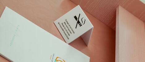 A white envelope with a logo and text, and a white box with a smoking cigarette symbol and text.