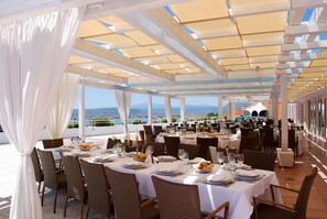 An outdoor dining area with tables set for guests, featuring a view of the landscape. - Luna Lughente (Olbia)