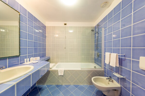 A bathroom with a bathtub, sink, and mirror. - Luna Lughente (Olbia)