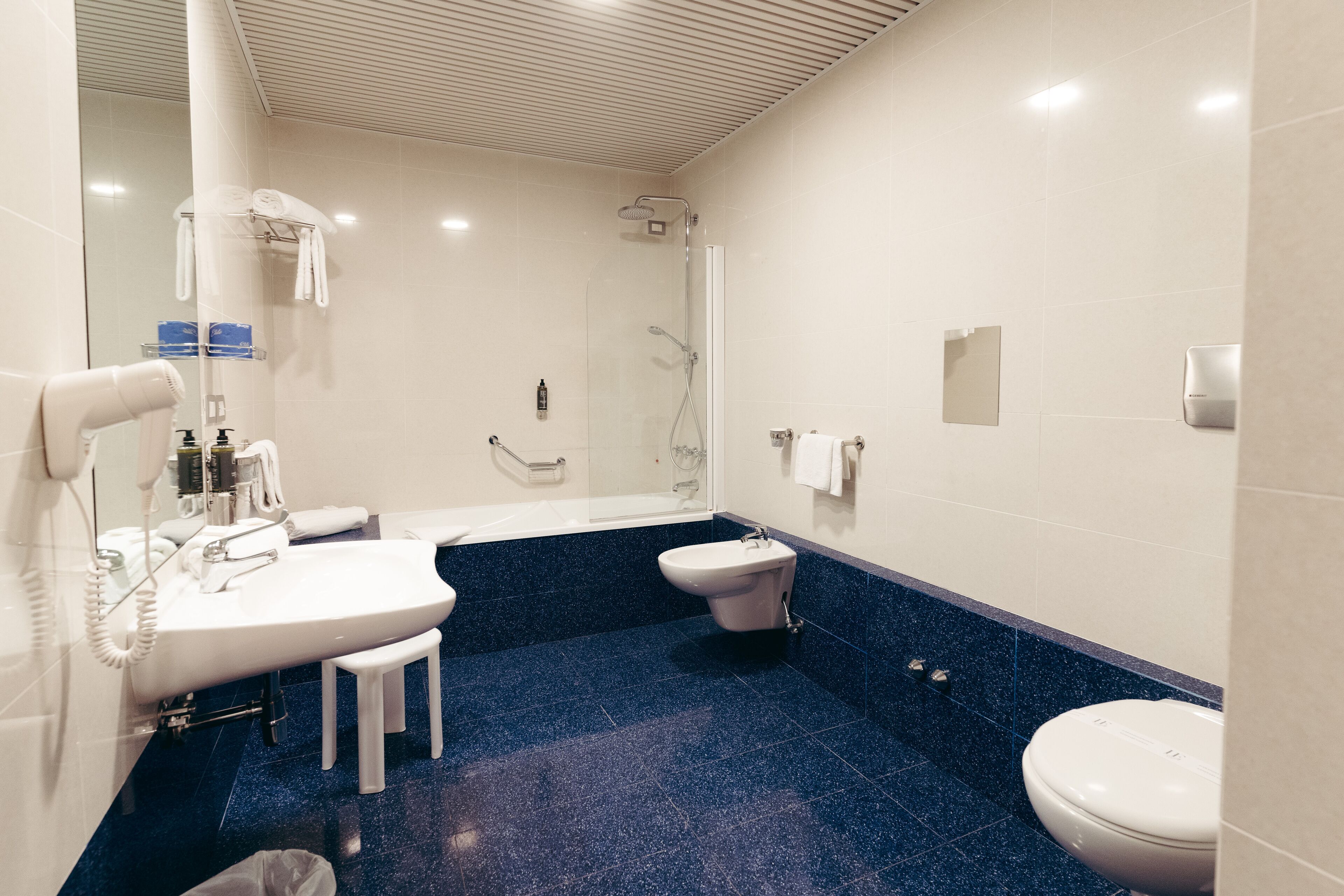 A modern bathroom with a sink, toilet, and shower.