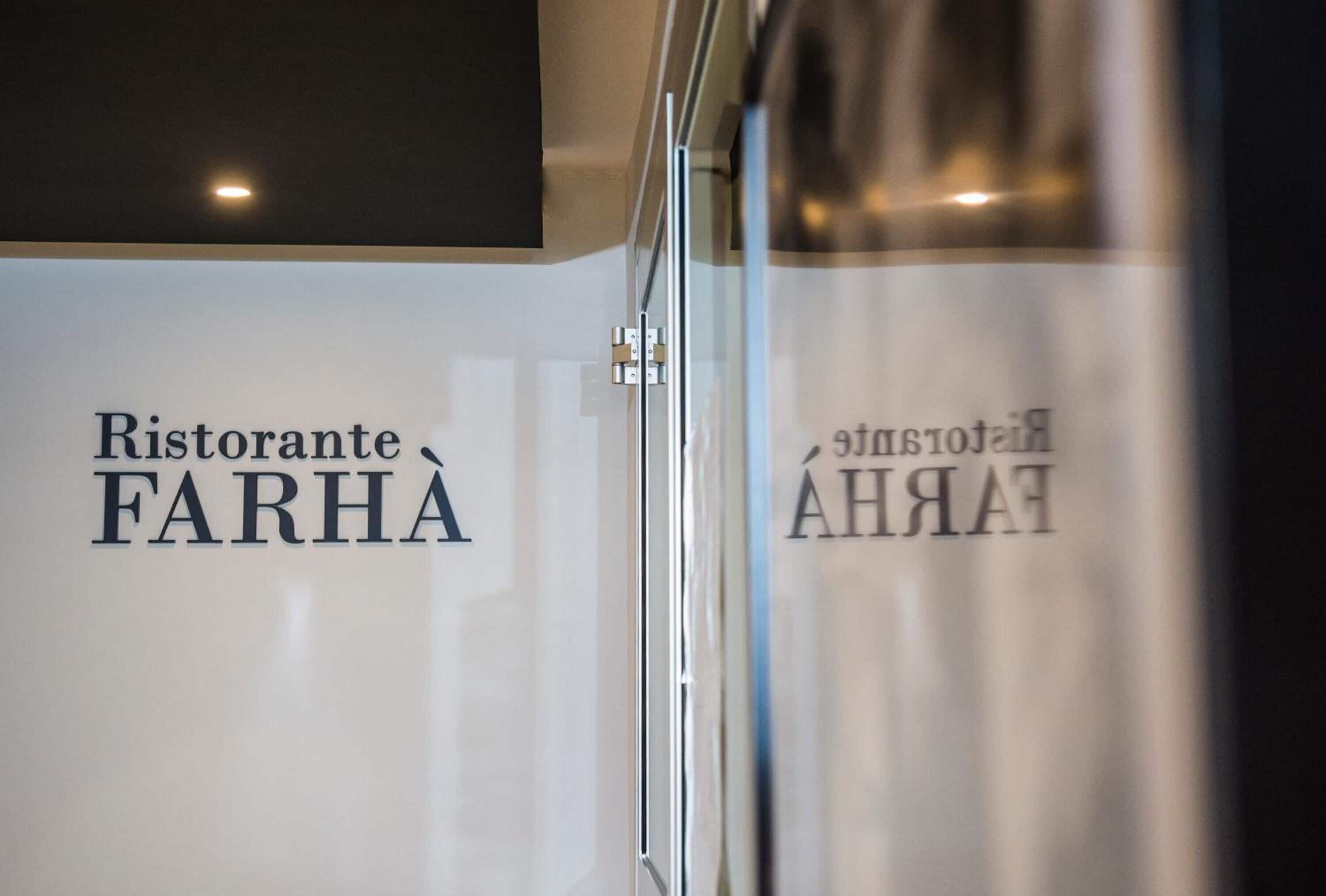 A sign with the text "Ristorante FARHA" and a partial view of a bottle.
