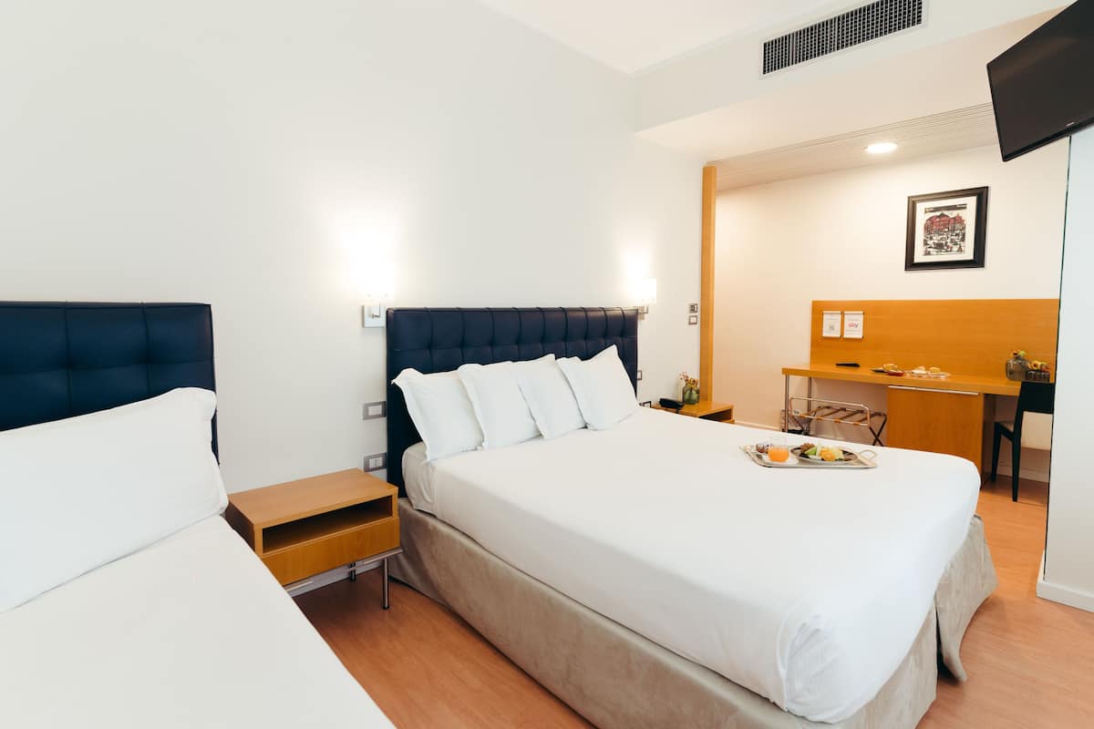 Ein Hotelzimmer mit einem großen Bett, einem Schreibtisch und einem Stuhl.