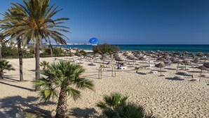A beach with palm trees, umbrellas, and lounge chairs. - SENTIDIO Phenicia (Hammamet)