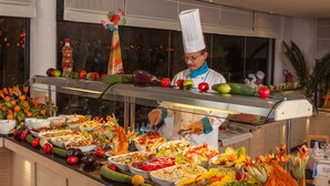 A buffet with various food items and a chef preparing food. - SENTIDIO Phenicia (Hammamet)