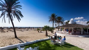 A beachside patio with outdoor seating and a covered area. - SENTIDIO Phenicia (Hammamet)