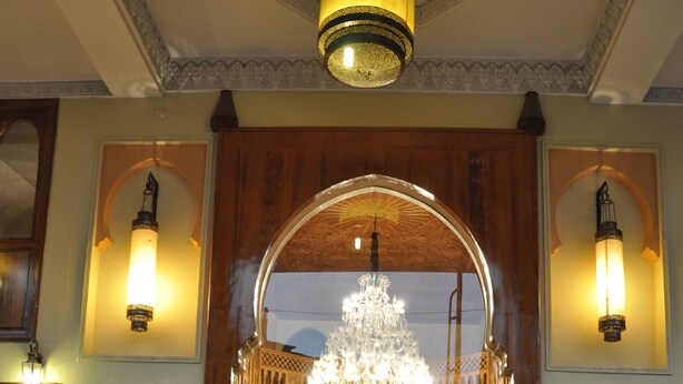 A hotel lobby with a grand chandelier, wooden arches, and seating areas. - Hotel Mont Gueliz (Marrakech)
