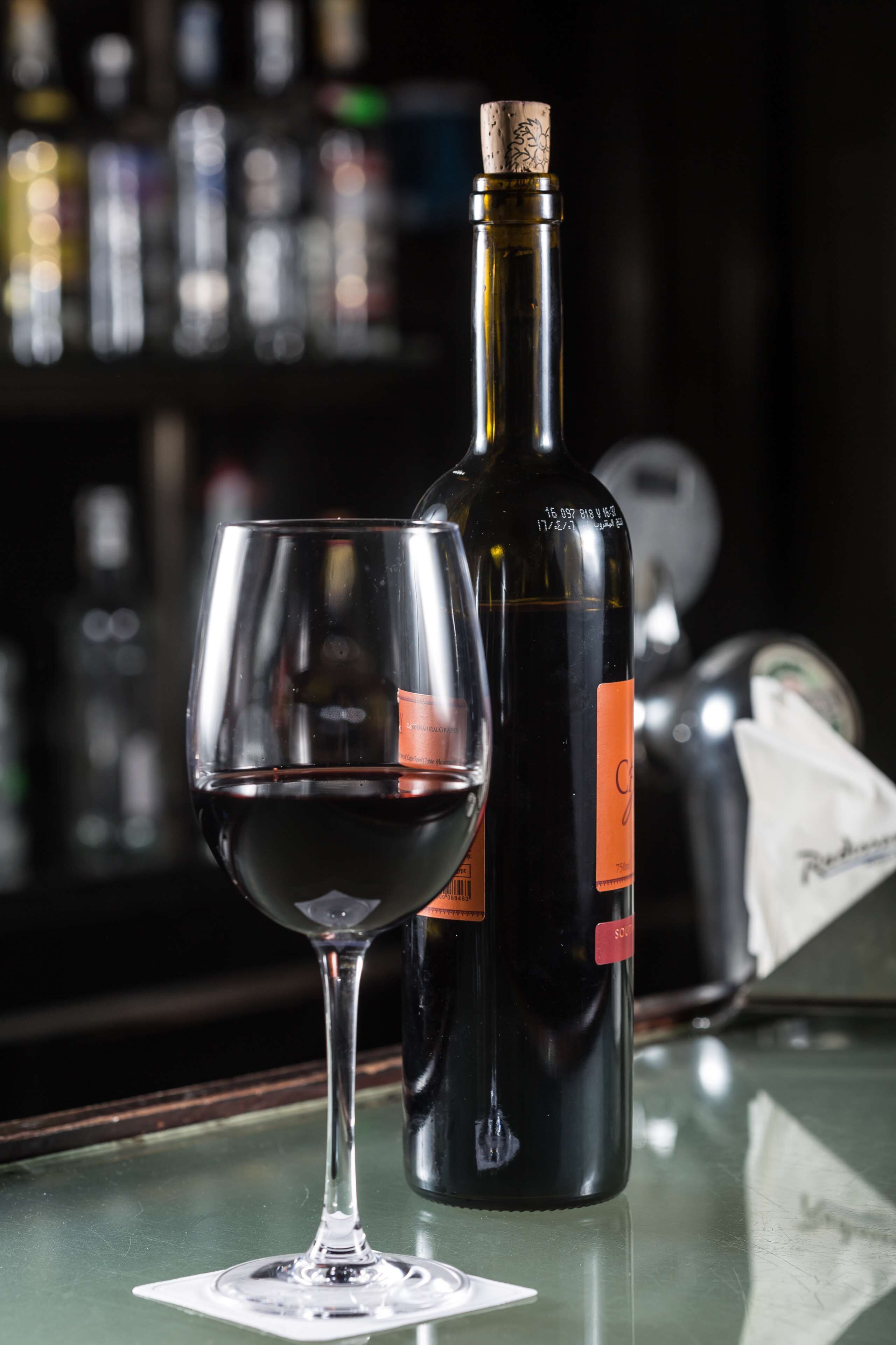Eine Weinflasche und ein Glas auf einer Bar.