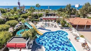 Un complexe hôtelier doté d’une grande piscine, d’un toboggan aquatique et offrant une vue sur l’océan.