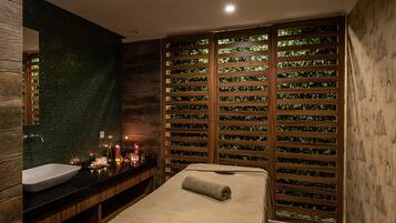 A modern bathroom with a large mirror, a sink, and a wooden wall with a green mosaic pattern.