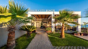 Een modern gebouw met een bord waarop “WHITE CITY BEACH” staat en een bord met daarop “COFFEE HOUSE”.