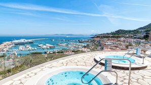 A hot tub area with a view of a marina and coastal town. - Hotel Gran Paradiso (Casamicciola Terme)