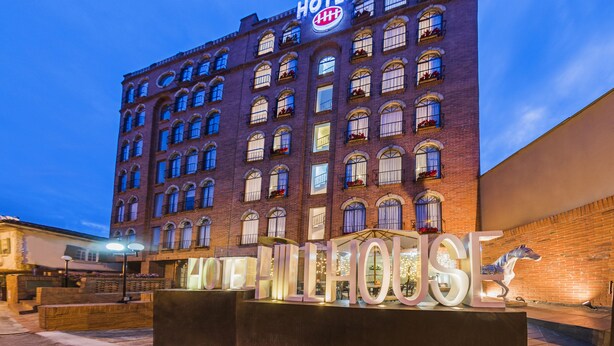 A hotel with a classic brick facade, multiple windows, and a prominent sign. - Hotel Hill House (Bogotá)