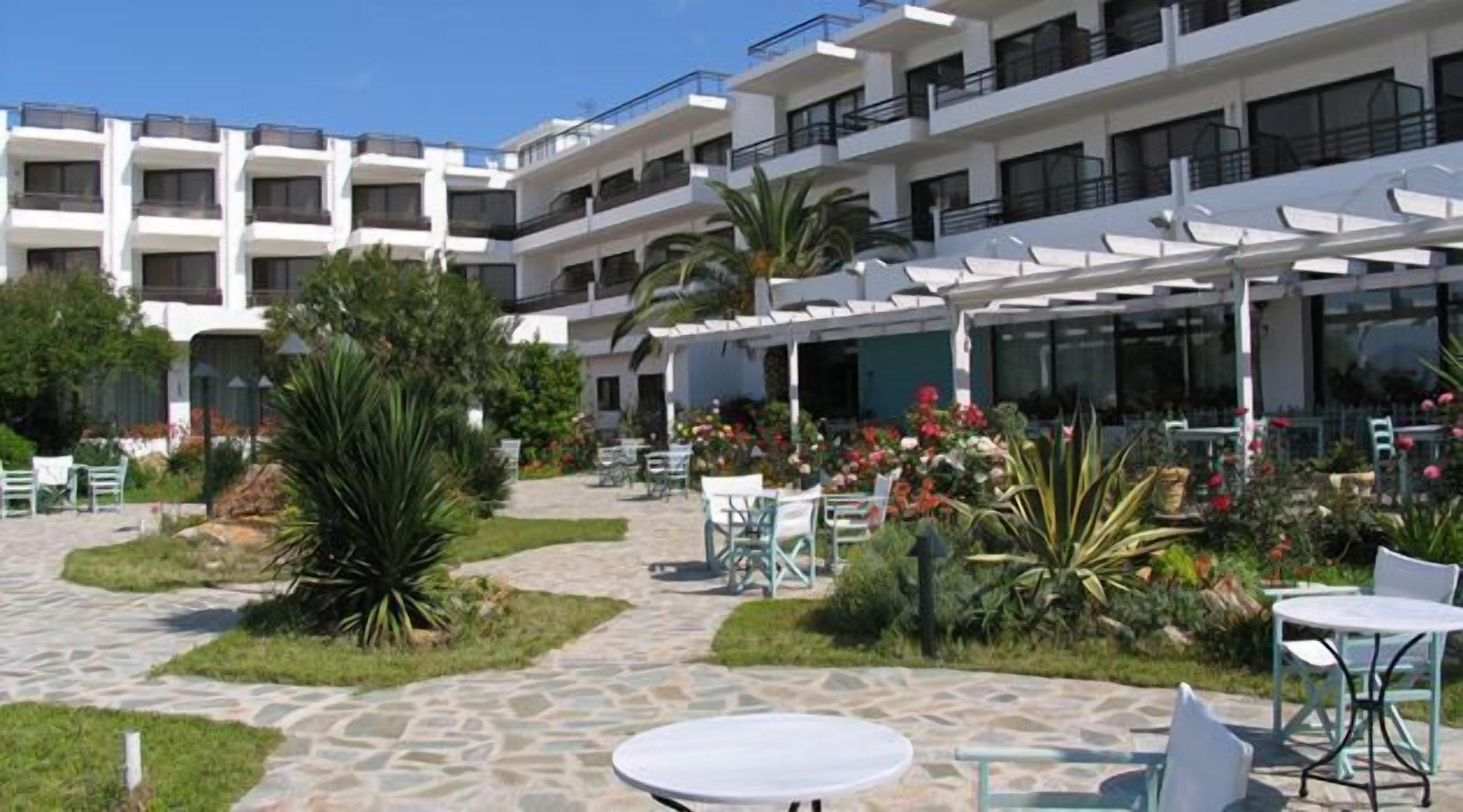 A courtyard with outdoor seating, a pool, and a building with multiple balconies.