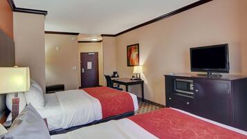 A hotel room with two beds, a desk, a television, and a microwave.