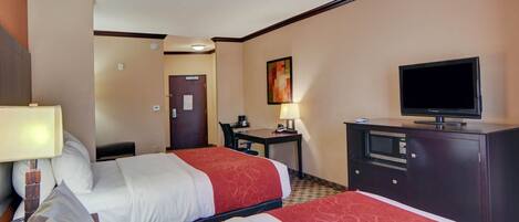 A hotel room with two beds, a desk, a television, and a microwave.