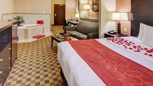 A hotel room with a bed, a desk, a chair, a sofa, and a small bathroom area. - Comfort Suites Kilgore (Kilgore)
