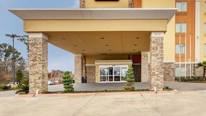 A Comfort Suites hotel entrance with a stone facade, a covered entrance area, and a clear sky. - Comfort Suites Kilgore (Kilgore)