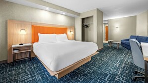 A hotel room with a large bed, a desk, a chair, a wardrobe, and a small table. - Fairfield Inn & Suites by Marriott Gadsden (Gadsden)
