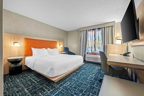 A hotel room with a bed, a desk, a chair, a TV, and a window with curtains. - Fairfield Inn & Suites by Marriott Gadsden (Gadsden)