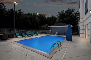 A swimming pool with lounge chairs, a covered seating area, and a building in the background. - Fairfield Inn & Suites by Marriott Gadsden (Gadsden)