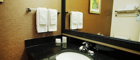 A bathroom with a black granite countertop, a white sink, and a large mirror.