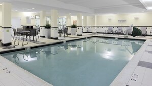 An indoor swimming pool with lounge chairs and a seating area. - Fairfield Inn & Suites by Marriott Bartlesville (Bartlesville)