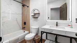 A modern bathroom with a bathtub, toilet, and vanity. - The Beverly House by AGA - Beverly Hills (Los Angeles)