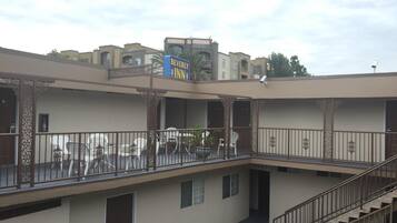 A multi-story building with a Beverly Inn sign, a staircase, and a balcony with railings.