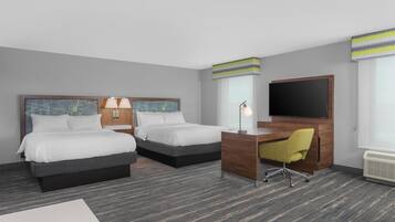 A hotel room with two beds, a desk, a chair, a TV, and a window with blinds.