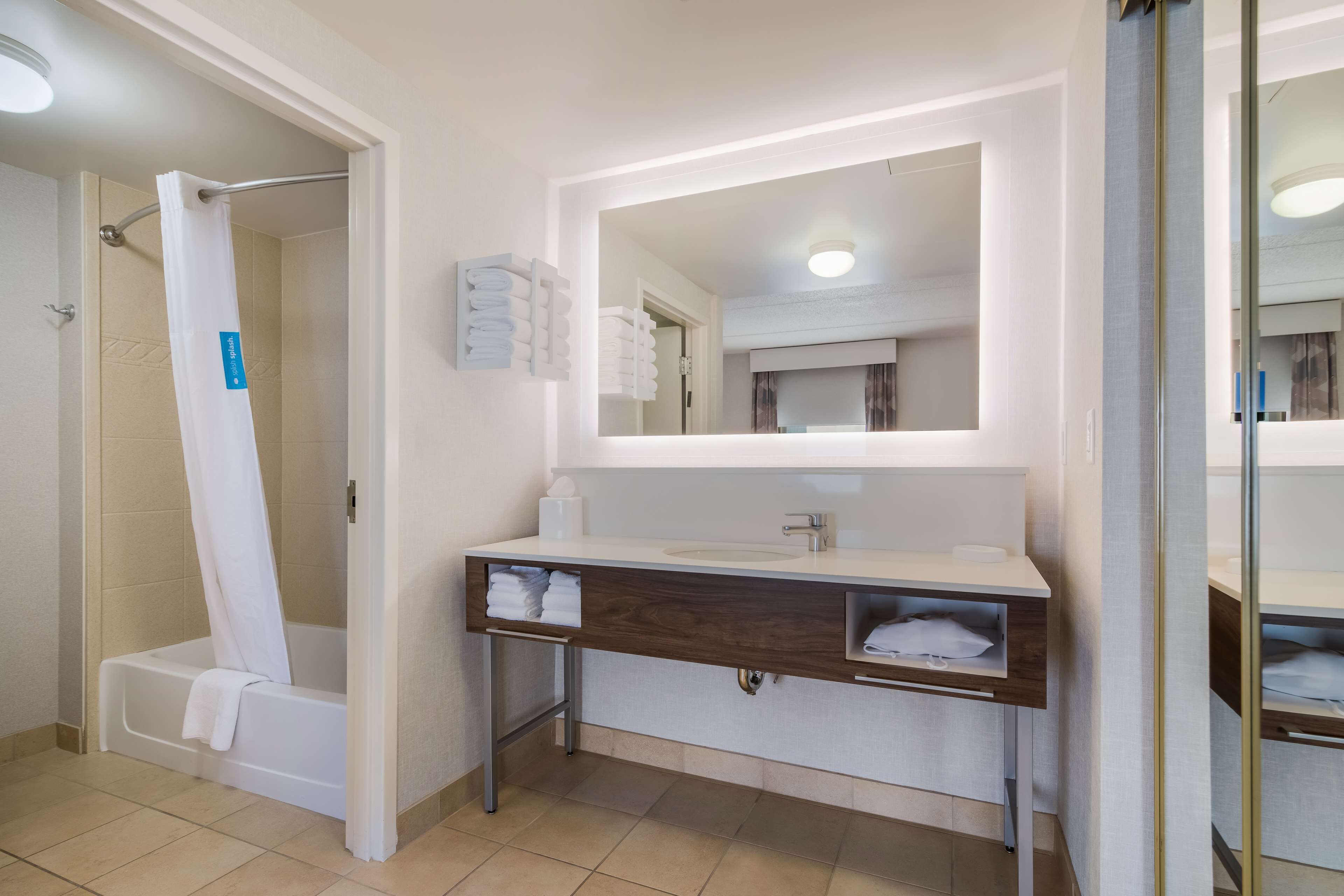 Ein modernes Badezimmer mit Badewanne, Waschbecken und Spiegel.
