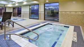 An indoor swimming pool with a metal ladder, tiled floor, and a view of the outside. - Hampton Inn & Suites Plattsburgh (Plattsburgh)