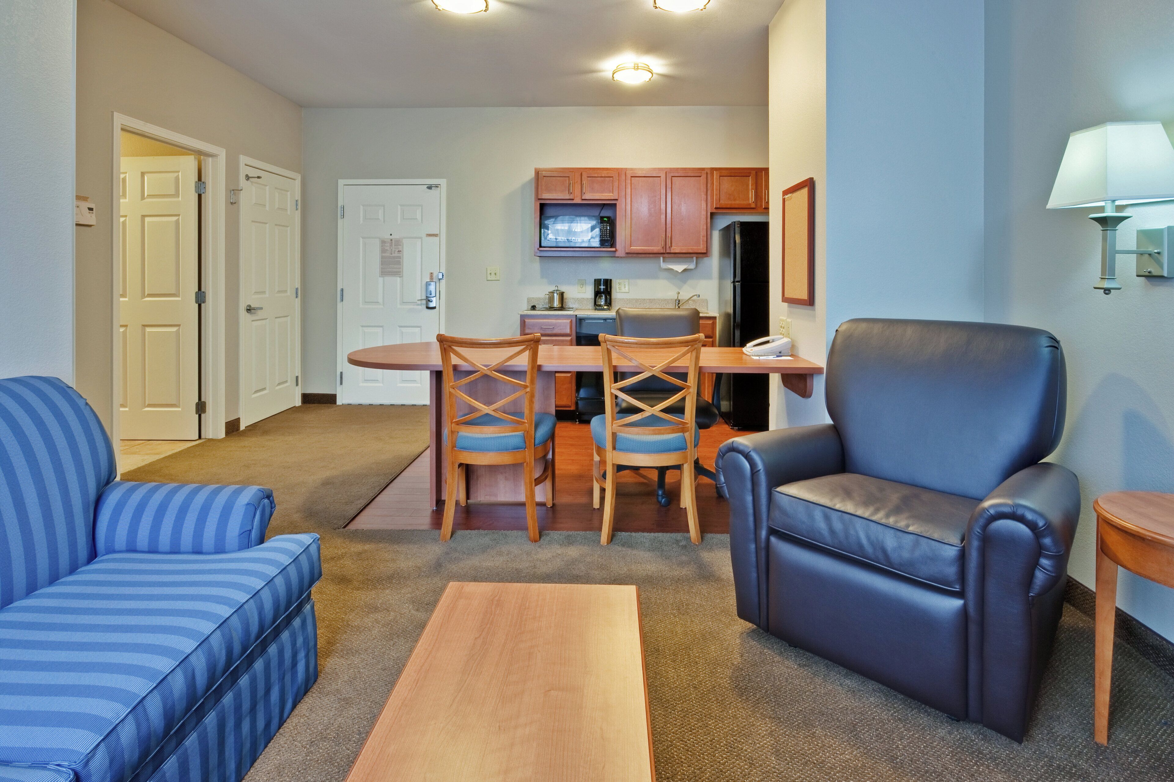 A compact living space with a kitchenette, a dining area, and seating.