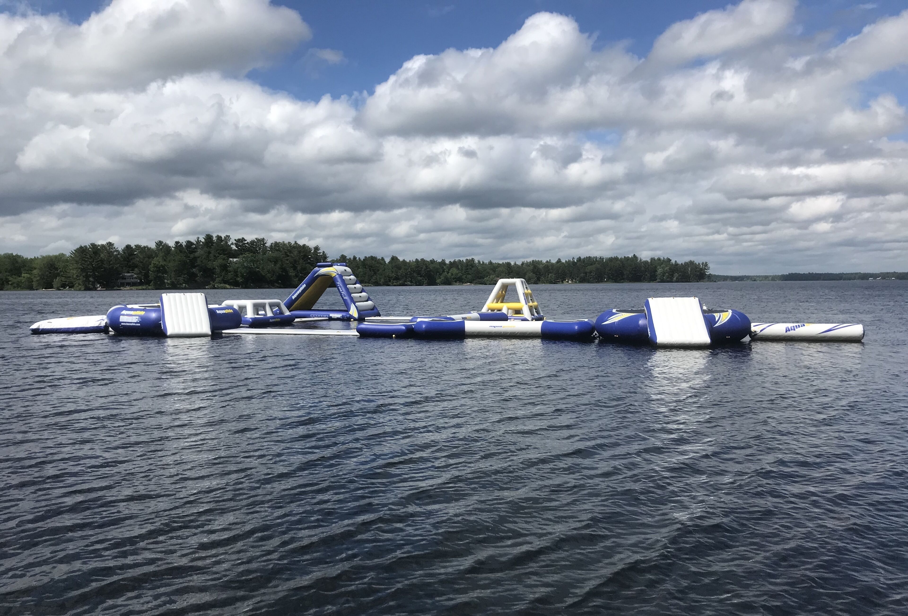 A series of floating platforms on a lake with a forested shoreline in the background.