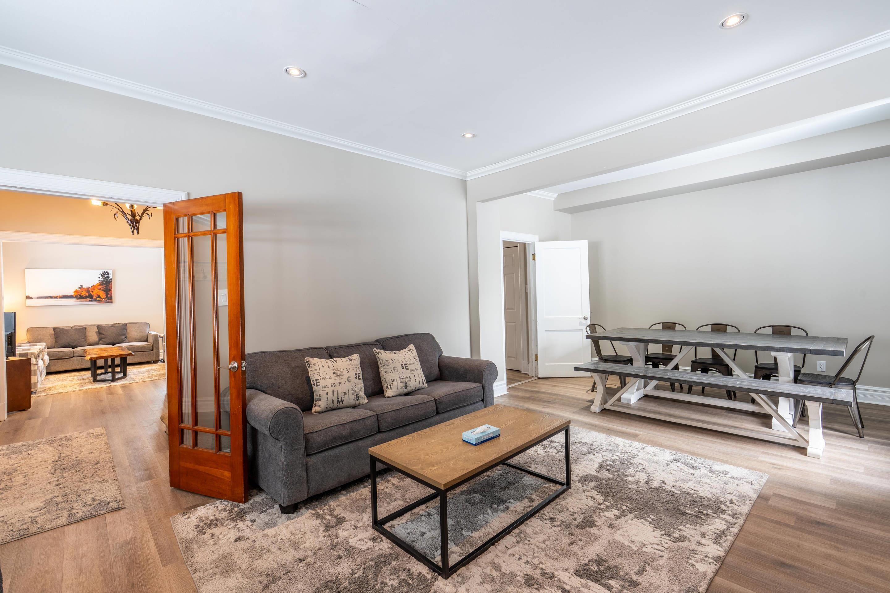 Una sala de estar con sofá, mesa de centro y mesa de comedor.