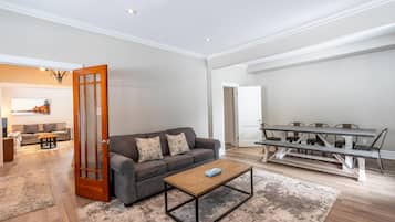 Una sala de estar con sofá, mesa de centro y mesa de comedor.