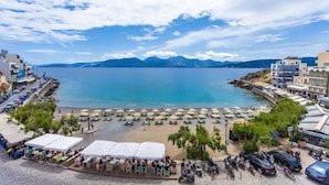 Un hôtel situé sur la côte, doté d’une terrasse, d’un accès à la plage et offrant une vue sur les montagnes.