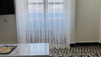 Departamento, vista al mar | Área de sala de estar | Televisión de pantalla plana de 24 pulgadas con canales digitales