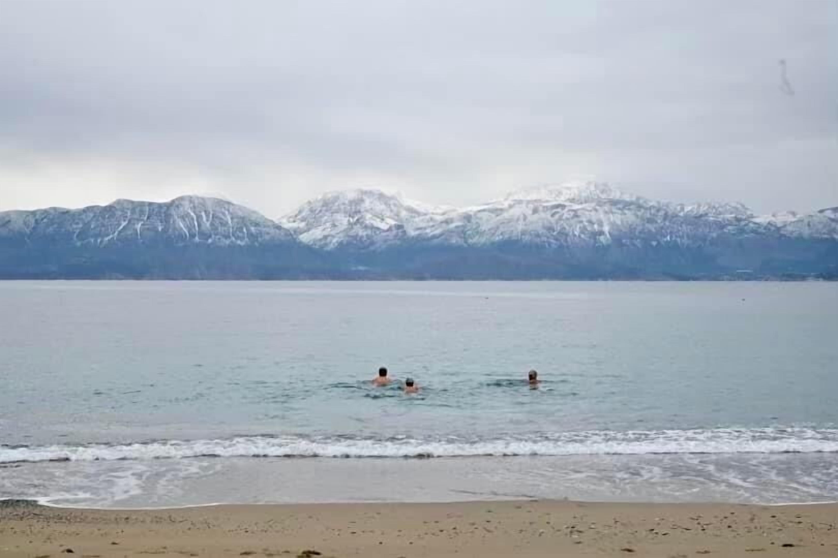 A beach with a mountain range in the background.