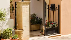 L’entrée de l’hôtel Palacio se distingue par son portail en arc de cercle, ses plantes en pot et une enseigne placée au-dessus de l’entrée.