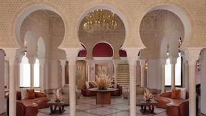Un intérieur agrémenté d’arches, d’un lustre et de différents espaces aménagés pour s’asseoir.