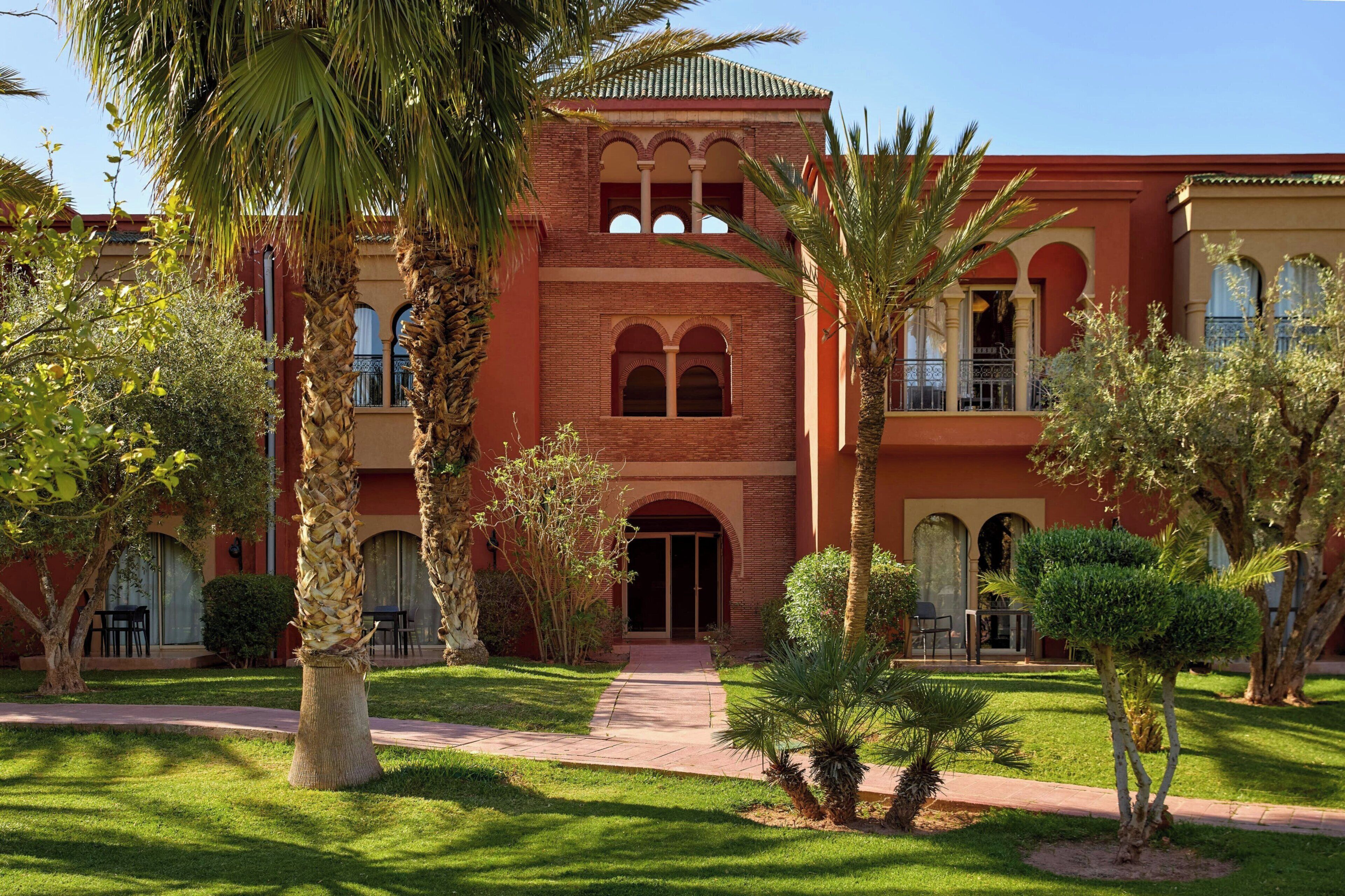 A building with a red facade, arched windows, and a central entrance.