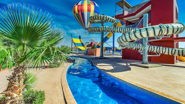 Un parc aquatique avec une montgolfière, des toboggans aquatiques et une piscine.
