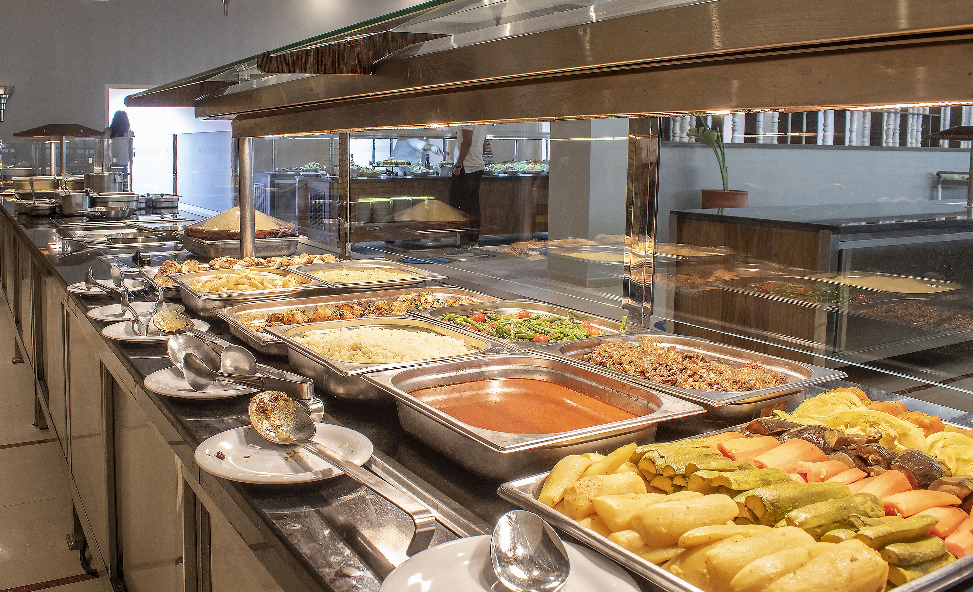 A buffet with various food items and utensils.