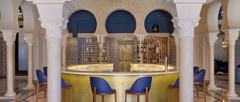A bar area with a counter, stools, and a decorative ceiling.