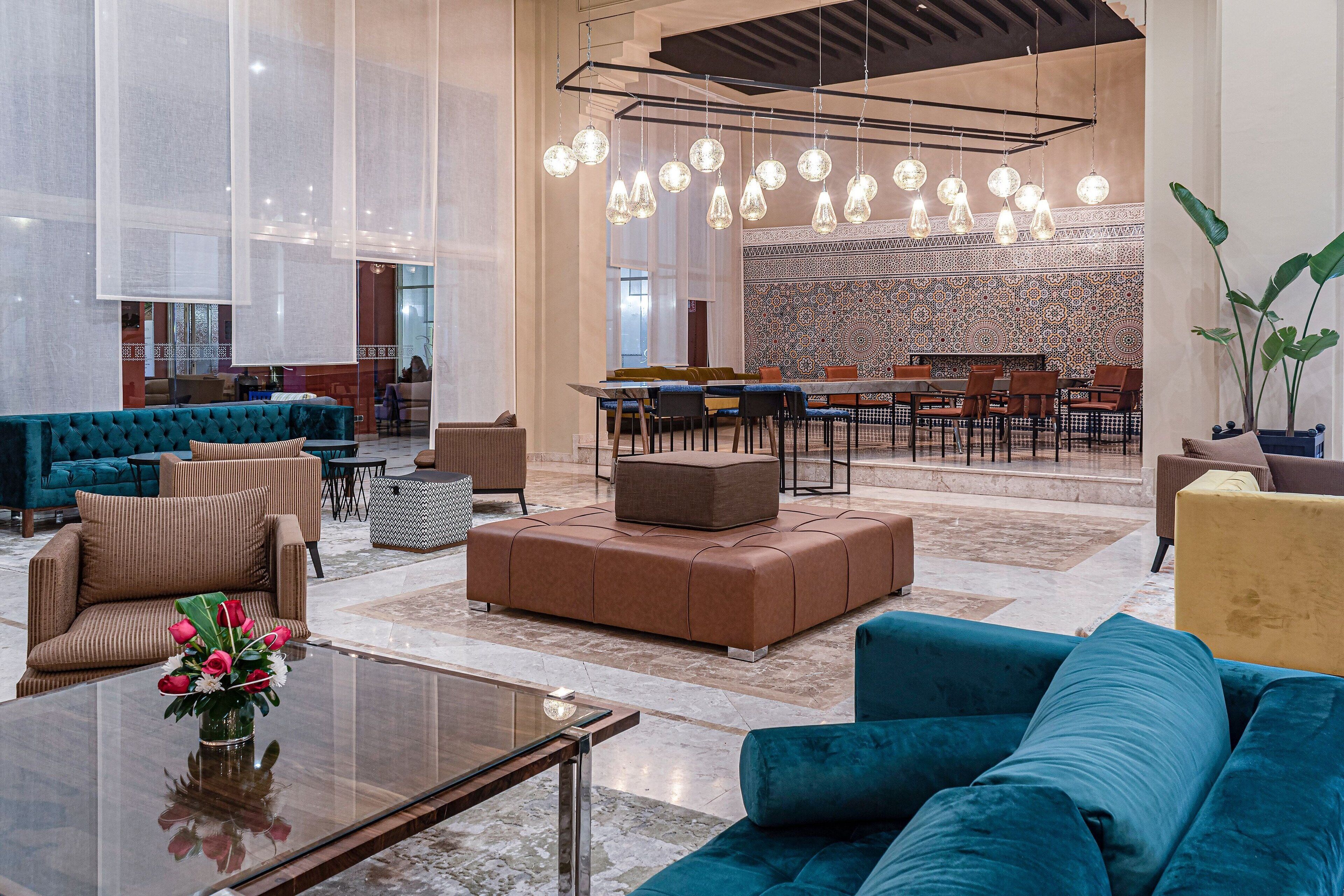 A spacious lobby with seating areas, a dining area, and a decorative wall.