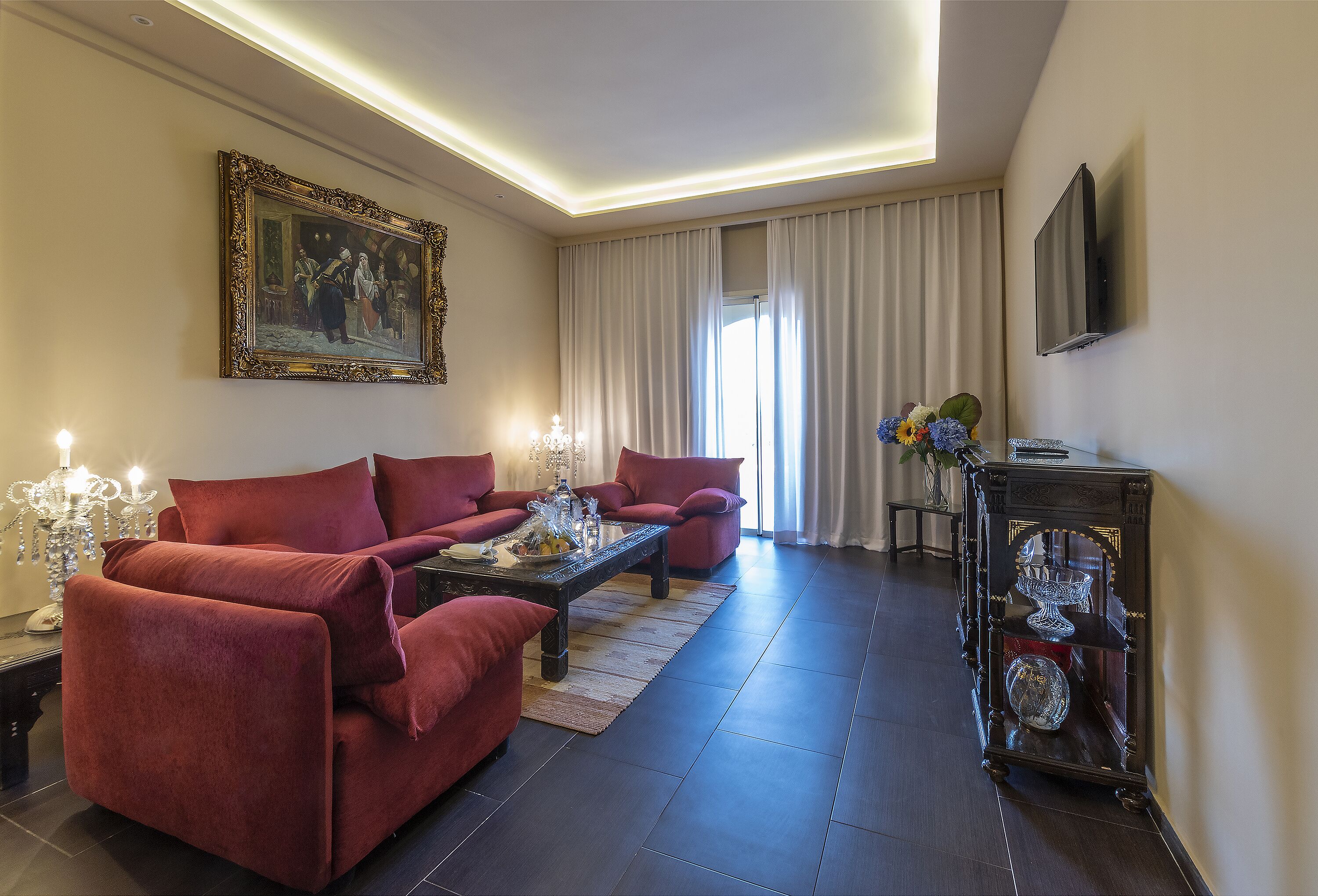 Una sala moderna con un sofá rojo, una mesa de centro y un espejo decorativo.