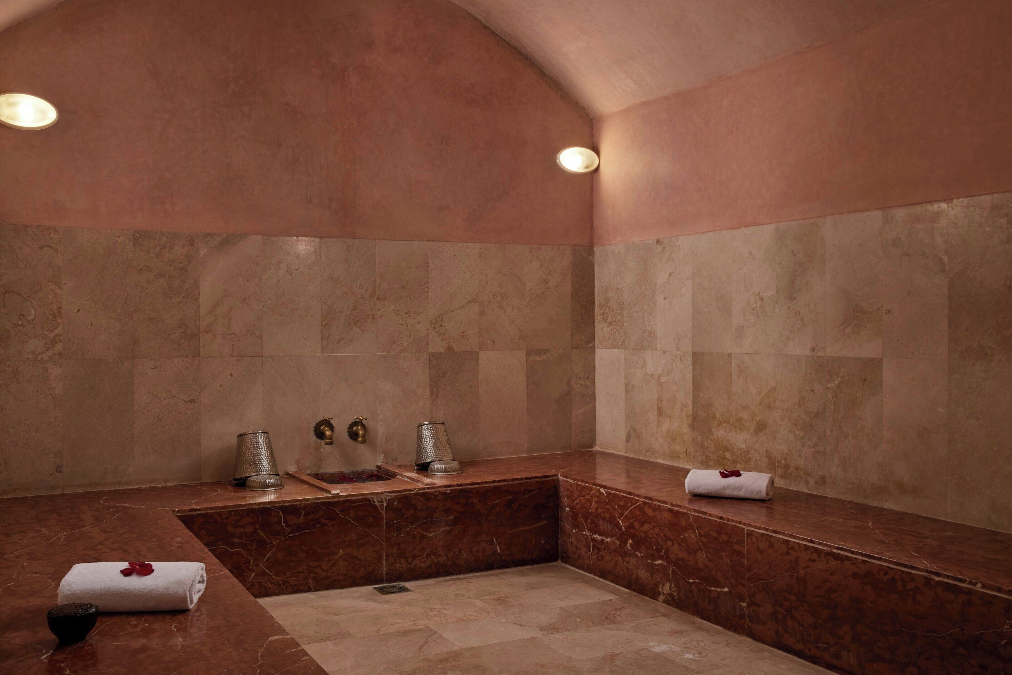 Un baño con lavamanos de mármol, bañera y zona de ducha.