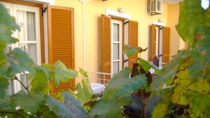 A building with multiple rooms, each with a window and a door. - Rantos Apartments (Corfu)