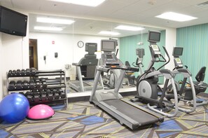 A gym with treadmills, elliptical machines, and a rack of dumbbells. - Holiday Inn Express Waterloo Cedar Falls by IHG (Waterloo)